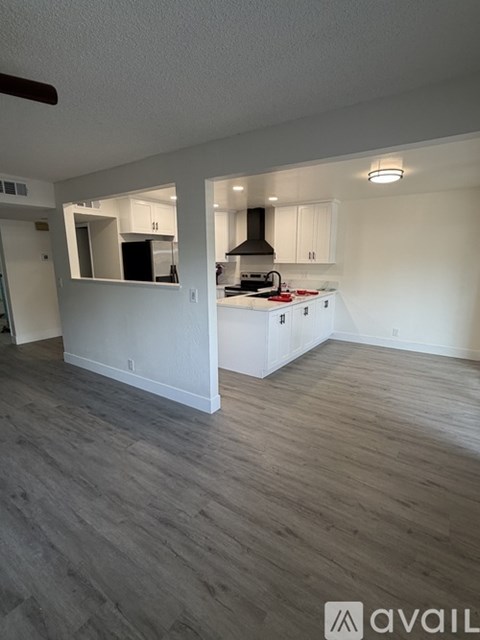 A kitchen with a stove top oven and a range hood.