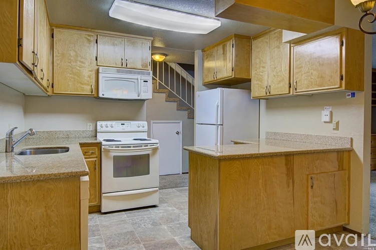 A kitchen with wooden cabinets and a stainless steel refrigerator.