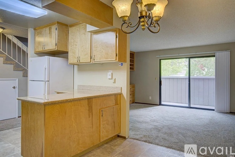 A kitchen area with wooden cabinets and a white refrigerator.