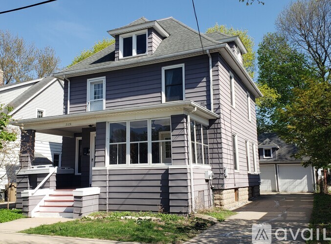 A two-story house with a grey exterior and a white garage door.