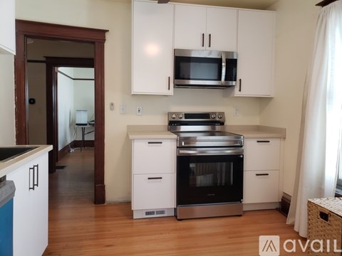 A kitchen with white cabinets and a black stove top oven.