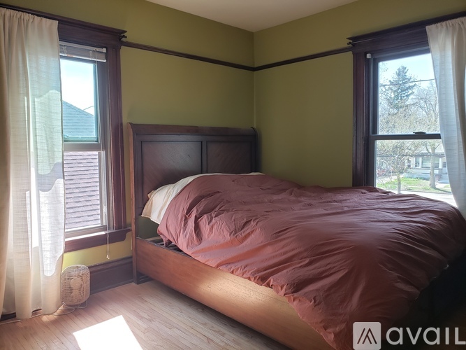 A bedroom with a bed, nightstand, and window.