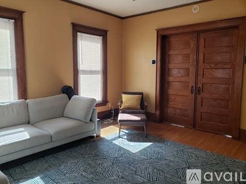 A living room with a white sofa and a wooden door.