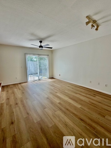 A room with wooden flooring and a ceiling fan.