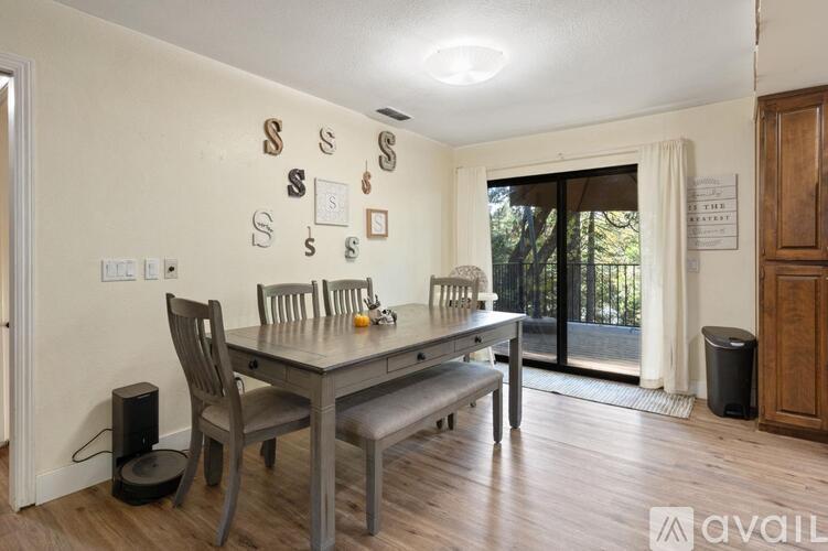 A dining room with a table, chairs, and decorative letters on the wall.
