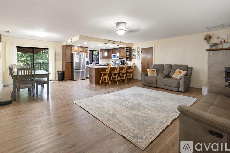 A living room with a grey couch and a rug.