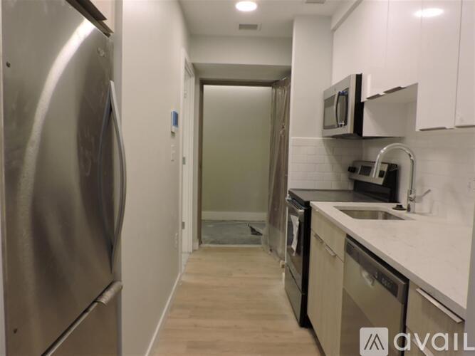 A kitchen with a stainless steel refrigerator and a sink.