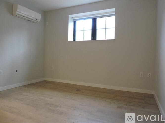 A room with a window and wooden flooring is available for rent.