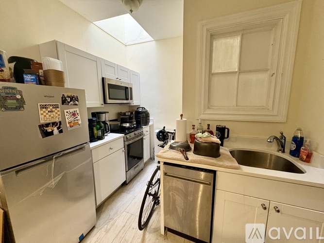 A white door is open to a room with wooden flooring.