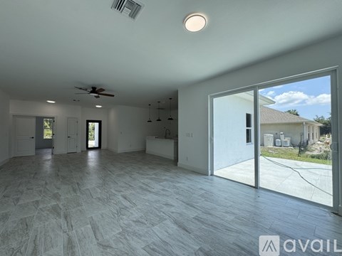 A spacious room with a sliding glass door leading to a backyard.