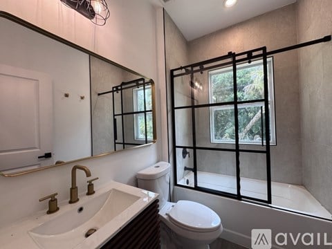 A bathroom with a white sink and a toilet.