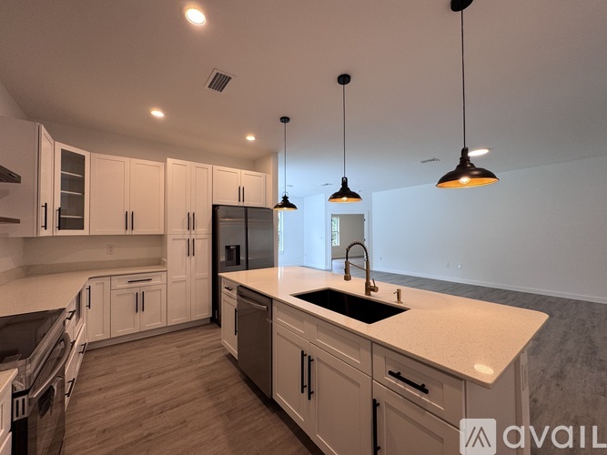 A kitchen with white cabinets and a marble countertop.