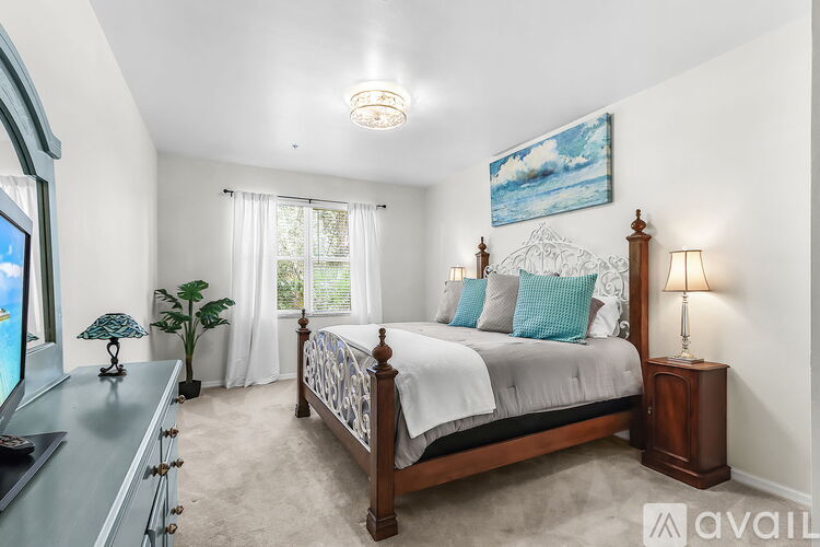 A bedroom with a large bed and a painting on the wall.