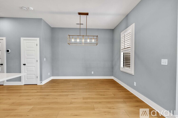 A living room with a white couch and a lamp on a side table.