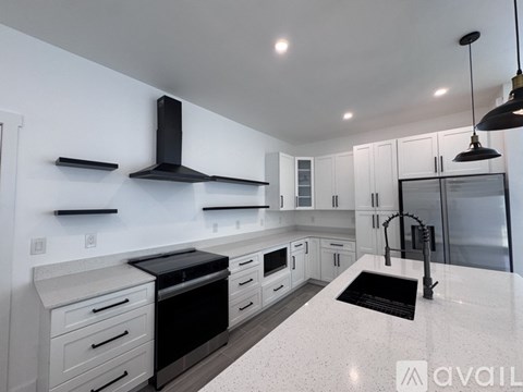 A modern kitchen with black and white appliances and cabinets.