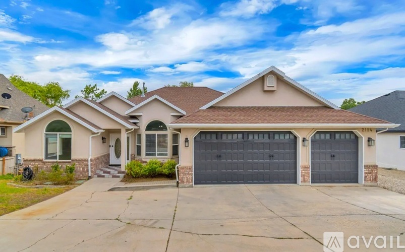 A house with a brown roof and two garages is for sale.