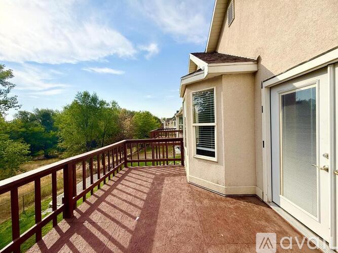 A balcony with a railing and a view of trees.