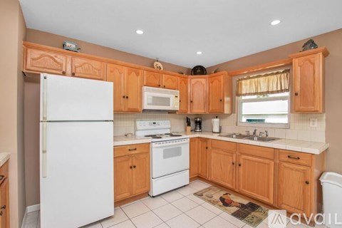 A kitchen with wooden cabinets and white appliances.