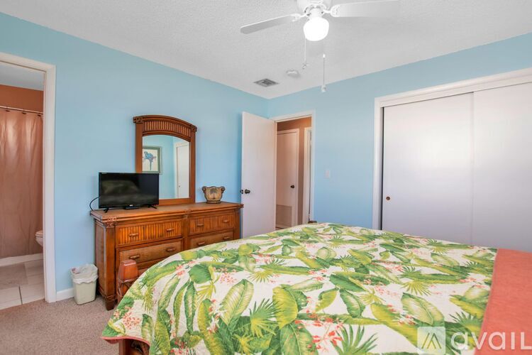 A bedroom with a bed, dresser, and mirror.