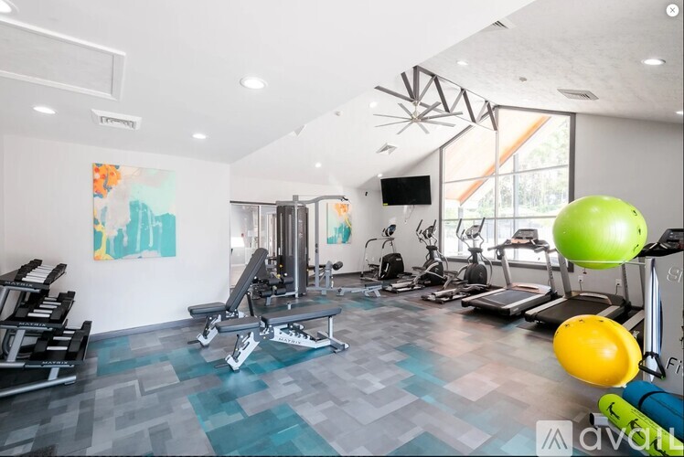 A gym with a variety of equipment including weights, a treadmill, and a stationary bike.