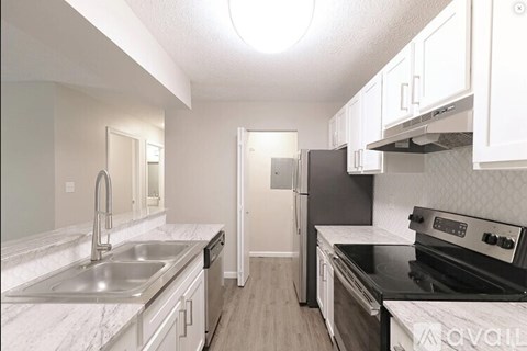 A kitchen with white cabinets and a black stove top oven.