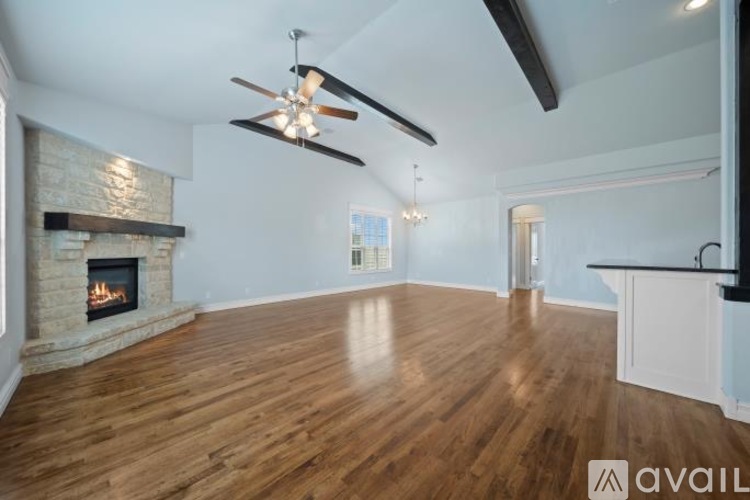 A spacious living room with a fireplace and hardwood floors.