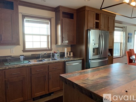 A kitchen with wooden cabinets and a granite countertop.