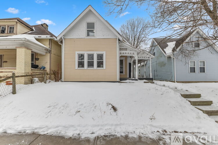 A house with a snow-covered front yard.