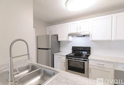 A kitchen with a stainless steel sink and a black stove.