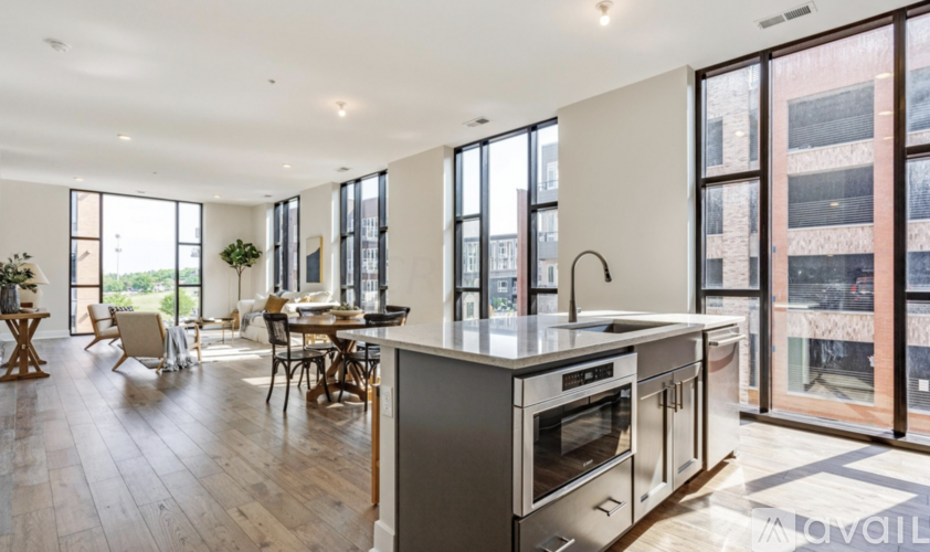 A modern kitchen with stainless steel appliances and wooden floors.