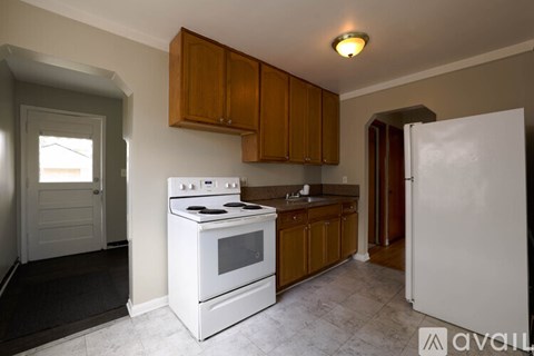 A kitchen with white appliances and wooden cabinets.