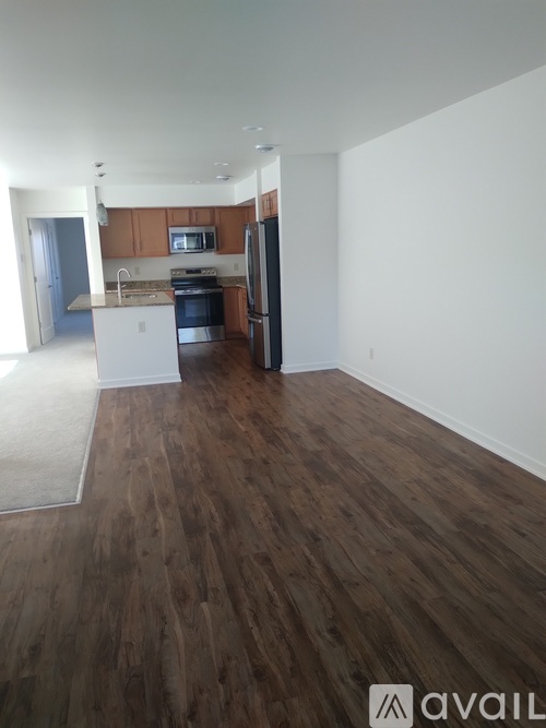 A kitchen with wooden floors and white walls.