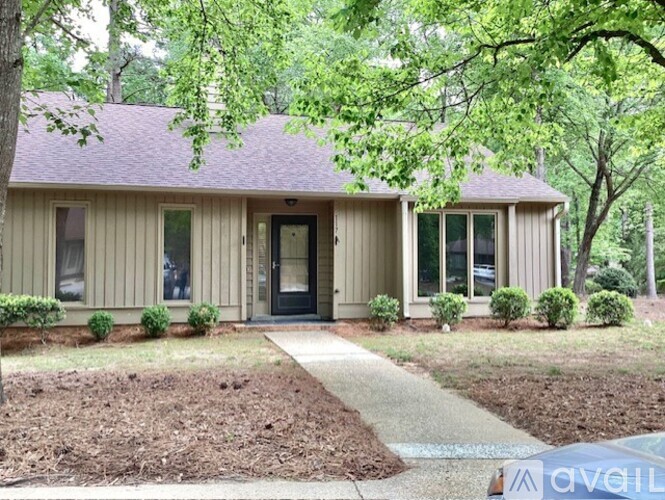A house with a front yard and a tree in front of it.