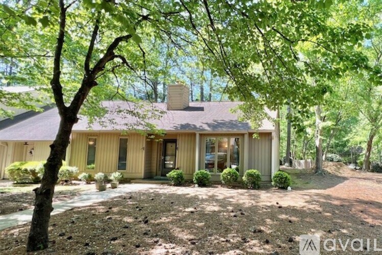 A house with a brown roof and a tree in front of it.