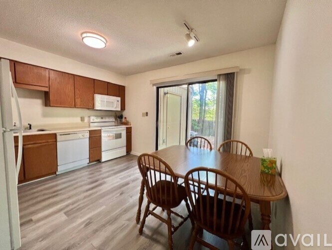 A kitchen with wooden chairs and a dining table is available for rent.