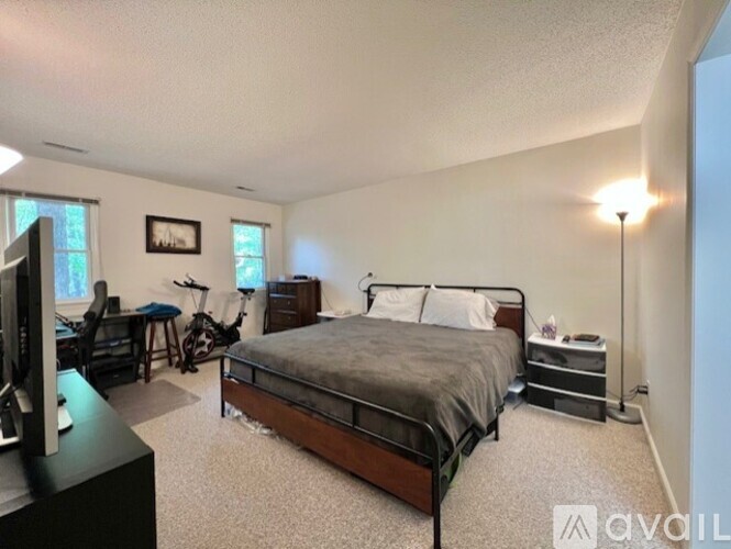 A bedroom with a bed, desk, and chair.