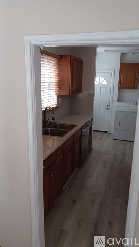 A kitchen with wooden cabinets and a white door.