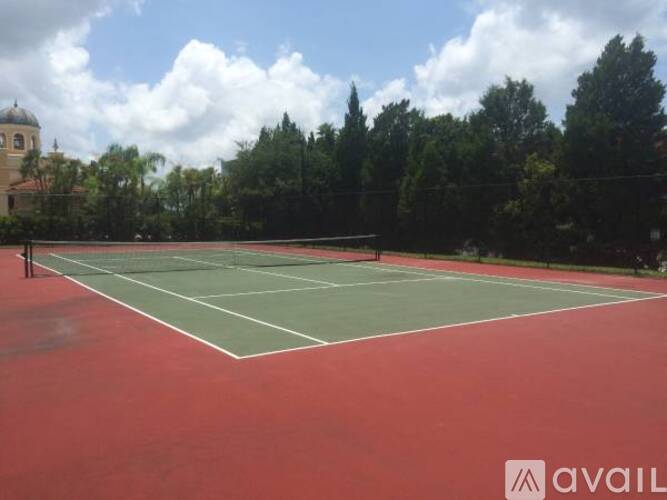 A tennis court with a net and trees in the background.