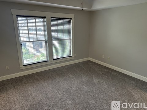 A room with a window and a carpeted floor.