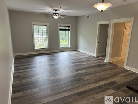 A room with wooden flooring and a ceiling fan.