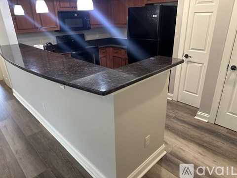 A kitchen with a black refrigerator and a countertop.