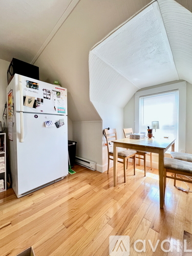 A kitchen with a white fridge and wooden floors.