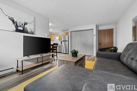 A modern living room with a grey sofa and a wooden coffee table.
