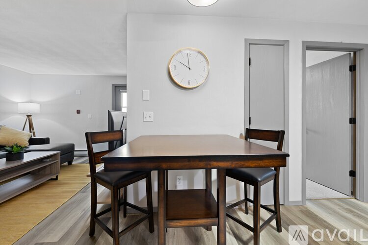 A dining room with a wooden table and chairs.