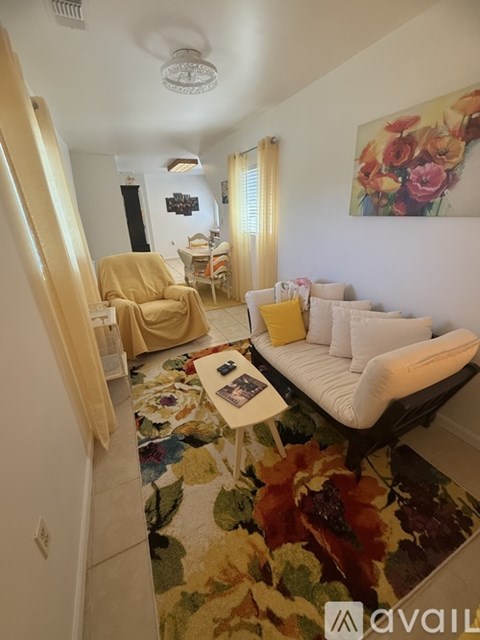 A living room with a yellow chair and a white couch.