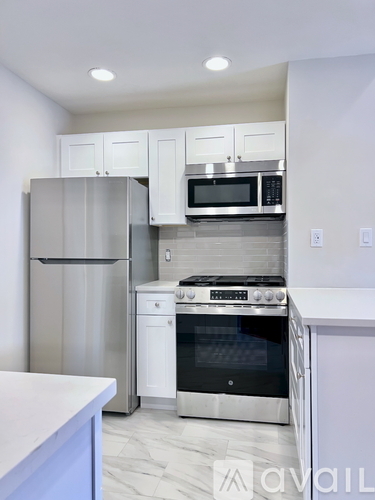 A kitchen with a stainless steel refrigerator, oven, and microwave.