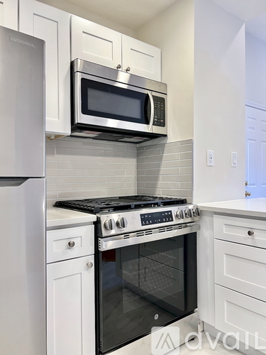 A modern kitchen with a stainless steel oven and microwave above it.