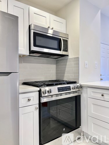A modern kitchen with a stainless steel oven and microwave above it.