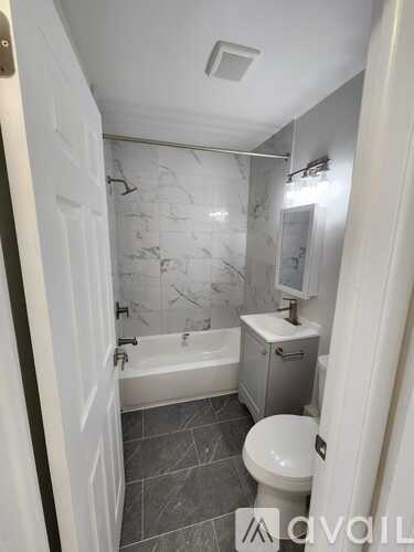 A bathroom with a toilet, sink, and bathtub.