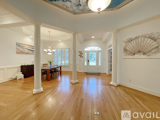 A spacious room with wooden floors and white walls.